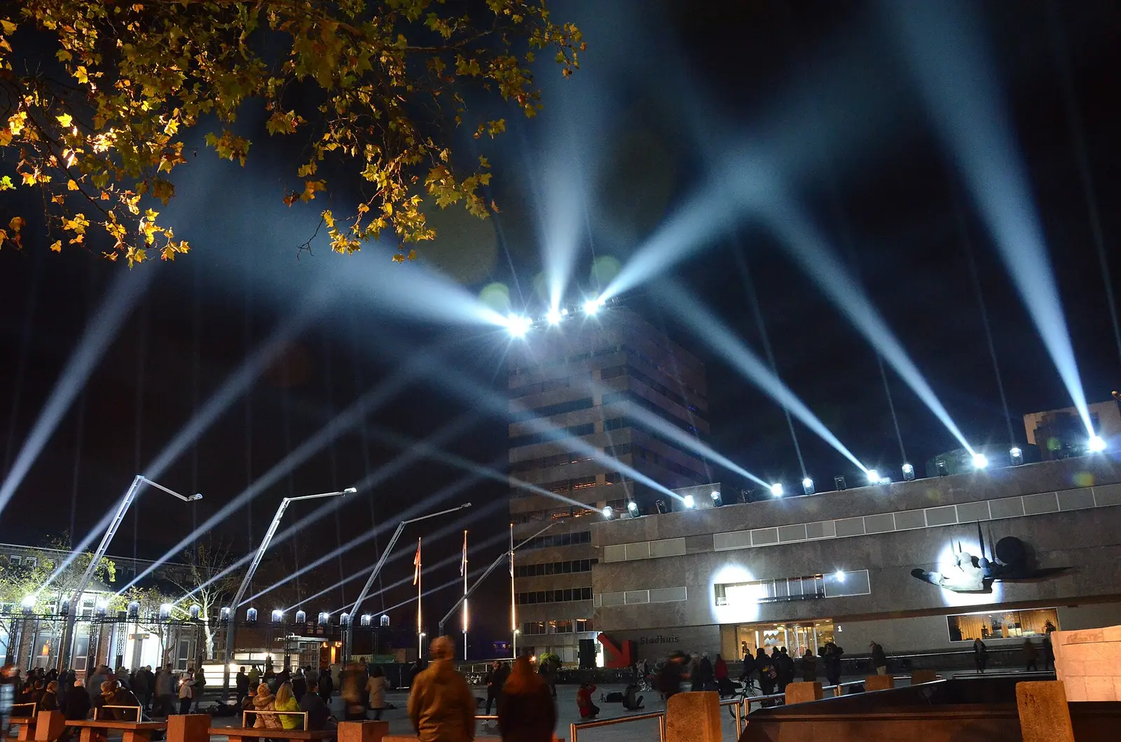 Beams of white light fan out over Stadhuisplein in Eindhoven at night during the GLOW light festival in 2017