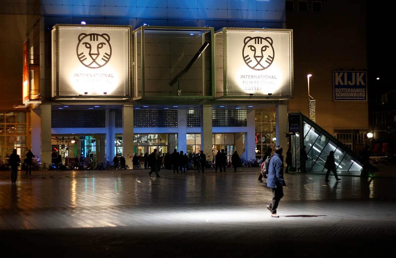 The entrance of de Doelen in Rotterdam at night with two lit International Film Festival Rotterdam tiger signs