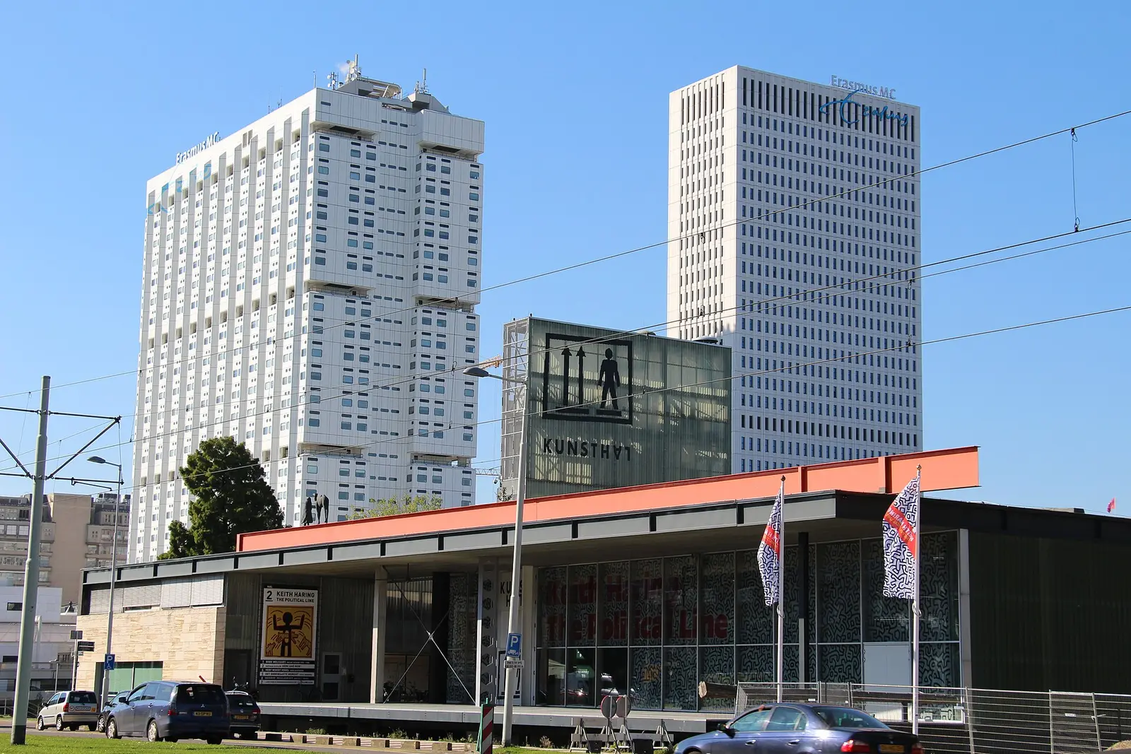 The low Kunsthal Rotterdam building with the Westzeedijk towers behind it under a blue sky