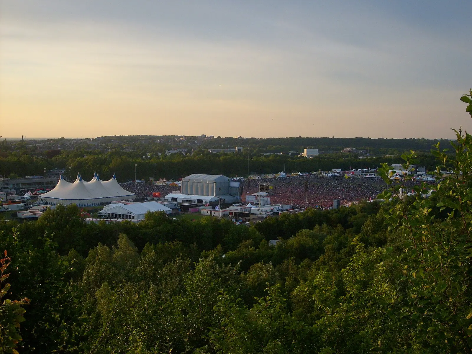 A hillside view over the Pinkpop festival site with white tents at Landgraaf