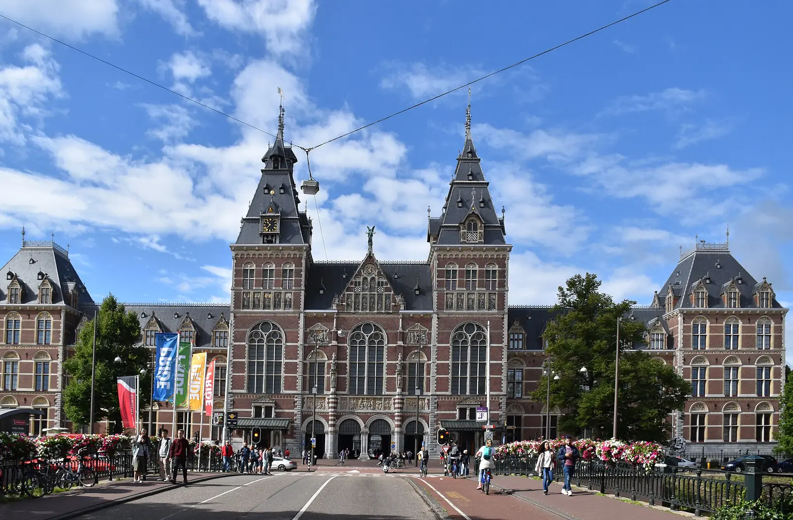 The north facade of the Rijksmuseum seen from the cycle path under a blue sky