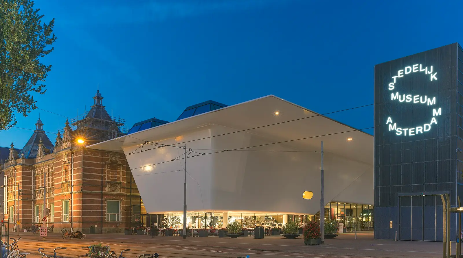 The new wing of the Stedelijk Museum and the old brick building at dusk