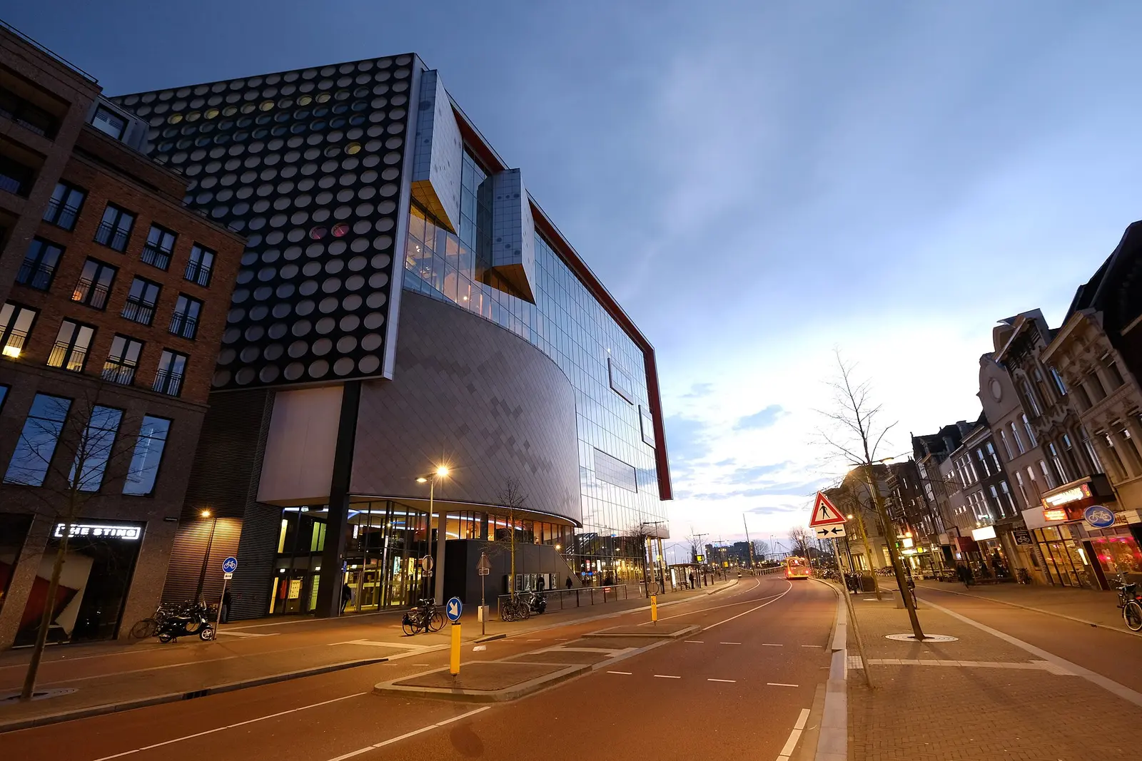 The glass and metal facade of TivoliVredenburg music centre in Utrecht at dusk