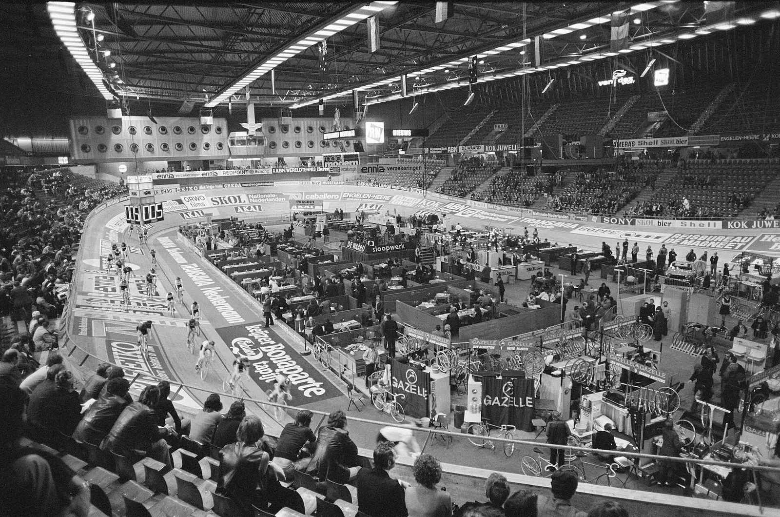 Black-and-white view over the banked track and infield of the Rotterdam six-day cycling race in the Ahoy hall in 1975